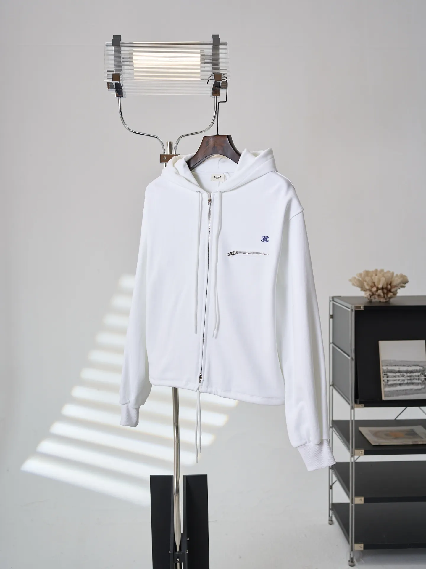 [Real auction] Celine/Celine logo embroidered zipper jacket (women's style) [In Stock] S M L custom-made light oxygen cotton-feel fleece knit, delicate and smooth, soft and skin-friendly. The body is laid out in clear white, with a soft cotton-like texture and rich layers. The elegant white tone brings a refreshing and clean daily atmosphere. The iconic Celine Arc de Triomphe embroidery is embellished on the chest, which is simple yet memorable. The simple hoodie silhouette sets a refreshing tone, and the two-way metal zipper design is full of texture. The short silhouette with loose, dropped shoulders gently modifies the lines of the shoulders and arms; the drawstring at the hem is adjustable to shape the silhouette as desired, and the short length optimizes body proportions. The simple silhouette carries a lazy atmosphere, and the relaxed outfit reveals the French girlish attitude. 1. Imported machine embroidery technology uses advanced computer control systems and precision mechanical components to precisely create the iconic TRIOMPHE logo embroidery, with smooth and delicate lines and a full sense of sophistication. 2. Fermentation washing treatment: The fabrics have been fermentation washing, which makes the hand feel and texture better, is not easy to deform, shrink, and fade, and maintains long-term beauty and loose fit.